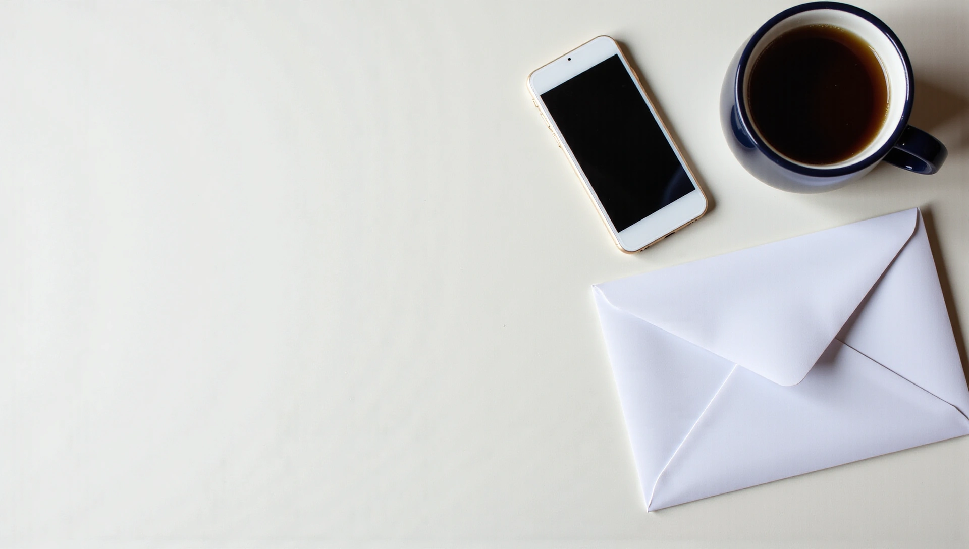 Teléfono, sobre y una taza de café en el escritorio, simbolizando la conexión y comunicación.